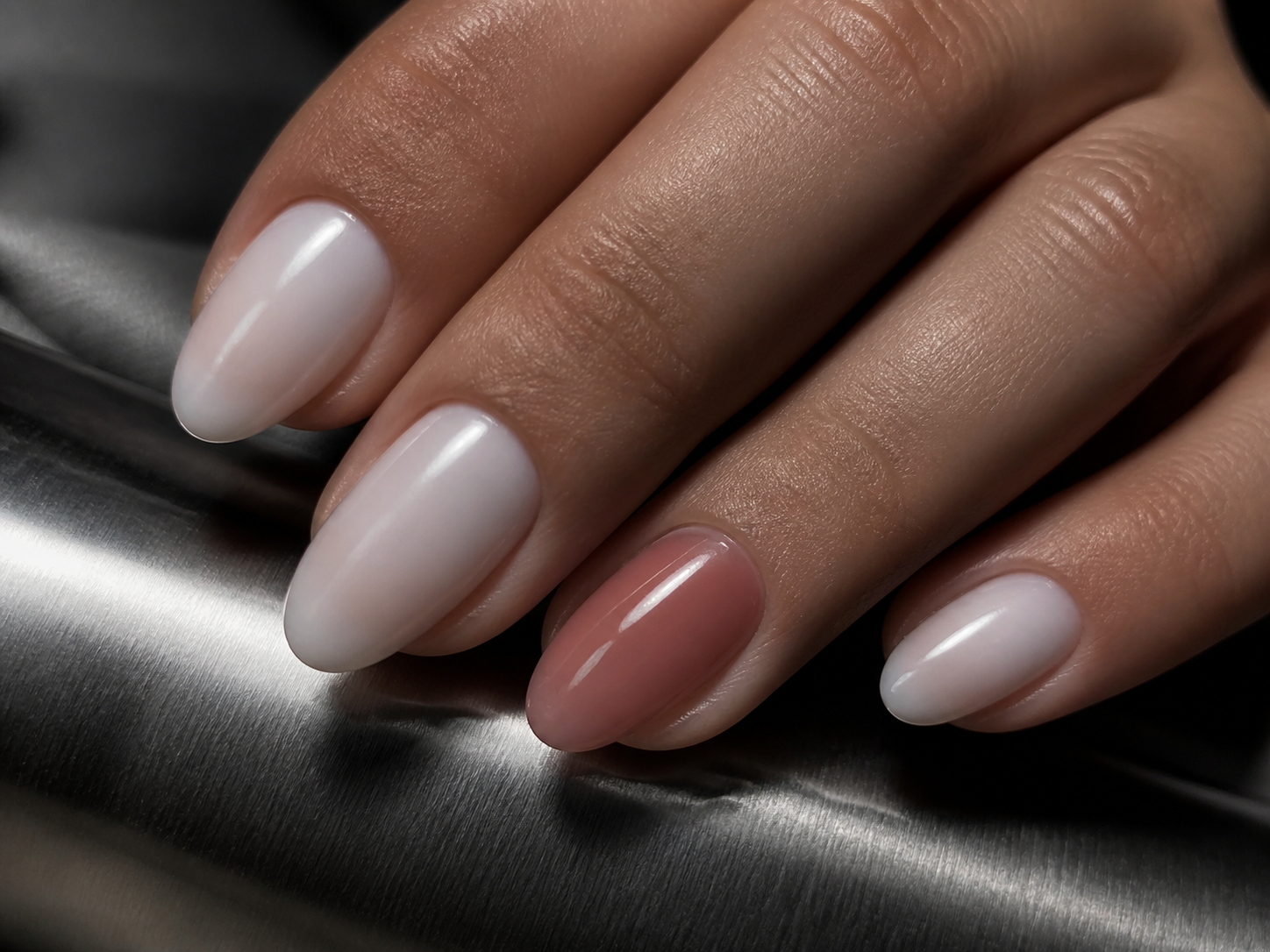 Close-up of a sculptural milky manicure with a rose accent